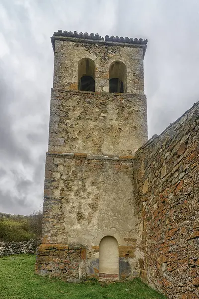 Vahşi bitki örtüsüyle çevrili tarihi taş kilise kulesi..