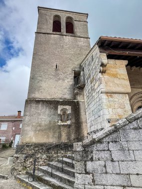 Villaverde 'de tarihi bir kilisenin devasa taş çan kulesi. Arkasında bulutlu bir gökyüzü var..