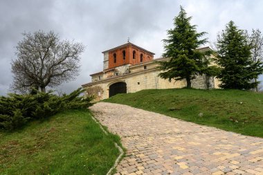 Taştan duvarları ve tuğladan kulesi olan bir tepedeki eski San Martin kilisesi..