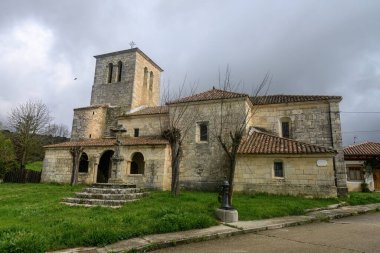 istorik taş kilise çan kulesi, kemerli veranda ve fayanslı çatı.