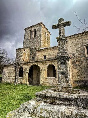 istorik taş kilise çan kulesi, kemerli veranda ve fayanslı çatı.