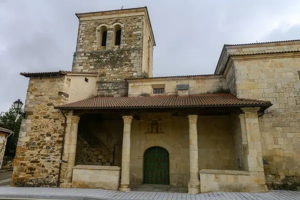 Çan kulesi ve Velilla de Palencia 'daki Portico' nun bulunduğu taştan kilisenin geniş görüşü.