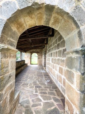 Romanesk bir taş kemerin içinden tahta çatılı taş bir portöre bak.