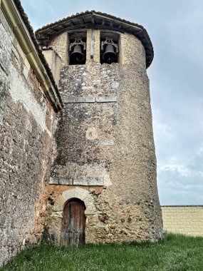 Tarihi bir taşra kilisesinde iki çan ve küçük kemerli pencereli antik taş çan kulesi..