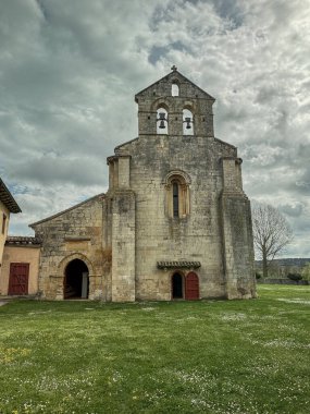 Santa Eufemia de Cozuelos Kilisesi 'nin taş ön cephesi. İspanya' nın Olmos de Ojeda şehrinde çan gable ve kemerli kapıları var..