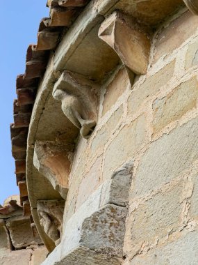 Romen kilisesinin duvarında yüzleri ve spiral motifi olan yontulmuş korbonların ayrıntıları