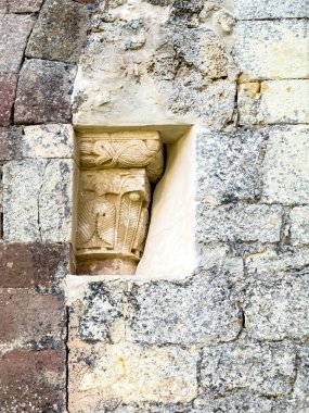 Eski kilise duvarında dekoratif motiflerle detaylandırılmış taş sermaye.