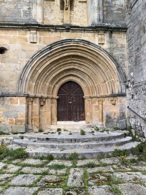 Yarı daire arşivleri ve İspanyol kilisesinde koyu ahşap kapılı taş giriş.