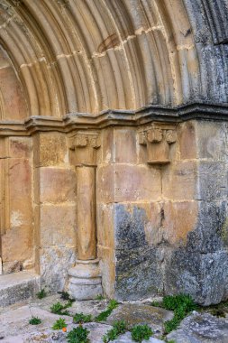 Yarı daire arşivleri ve İspanyol kilisesinde koyu ahşap kapılı taş giriş.