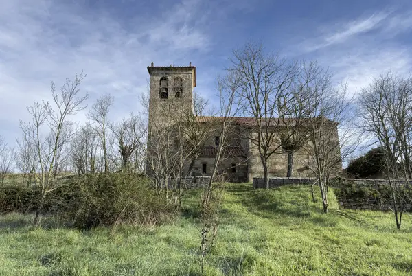İspanya 'nın huzurlu kırsalında kırmızı fayanslı çatısı ve çan kulesi olan küçük tarihi kilise.