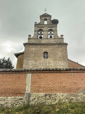 San Andres 'de çan kulesi olan tuğla kilise, San Andres de la Regla' da maymun ve leylek yuvası, Palencia.