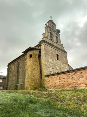 San Andres 'de çan kulesi olan tuğla kilise, San Andres de la Regla' da maymun ve leylek yuvası, Palencia.