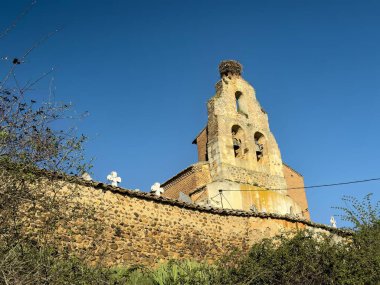 Mezarlık duvarında leylek yuvası olan San Justo y San Pastor Kilisesi 'nin taş çanı.