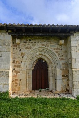Oyma taş detaylar ve ahşap kapıyla Romanca kemerli giriş.