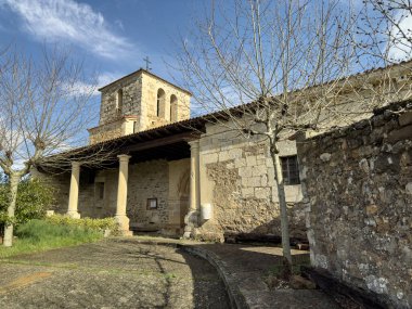 Güneşli bir günde girişi ve çan kulesi olan eski taştan kilise.