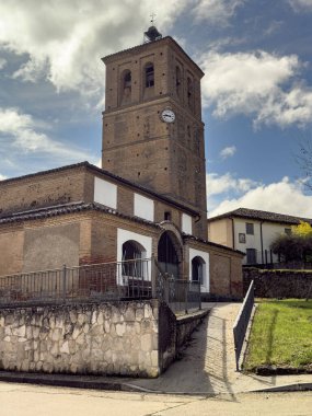 İspanyol köyünde çan kulesi ve saati olan eski tuğla kilise.