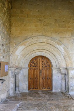 Dekoratif taş işçiliği ve ahşap kapıyla Roma tarzı kemerli bir giriş.