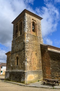 Bulutlu mavi gökyüzünün altında çan kulesi olan eski tuğla ve taş kilise