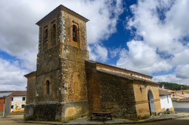 Bulutlu mavi gökyüzünün altında çan kulesi olan eski tuğla ve taş kilise