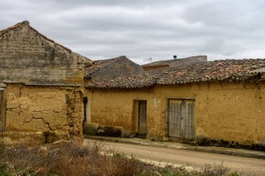Kiremitli çatılı ve kırsal kesimdeki yeşil kapılı kır evi.