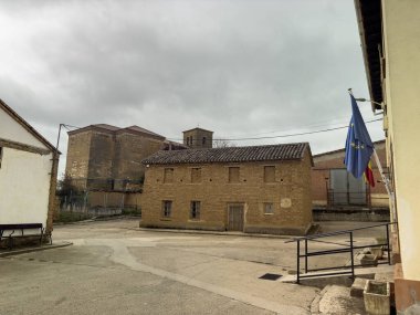 Kiremitli çatılı ve kırsal kesimdeki yeşil kapılı kır evi.