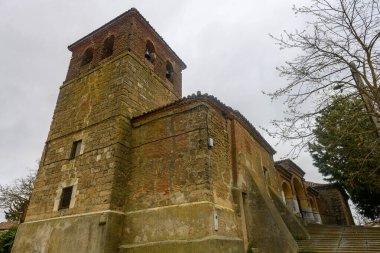 Çan kulesi ve kemerli verandalı taş ve tuğla kilise geniş bir merdiven tarafından erişilebilir.
