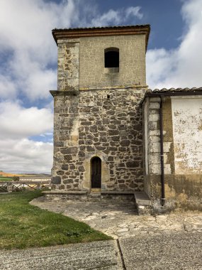 Olea de Boedo 'da çan kulesi ve taş kemerlerle boyanmış bir kilise.