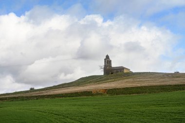 İspanya, Cembrero kırsalında çan kulesi ve kemerli pencereli tepedeki taş kilise.