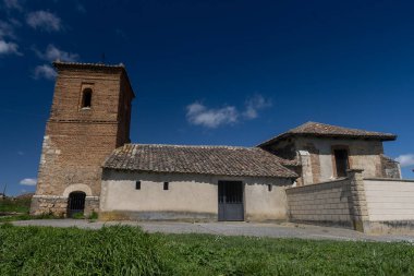 Palencia İspanya 'da çan kulesi ve terk edilmiş nesnelerle dolu eski taştan bir kilisenin kırsal manzarası.