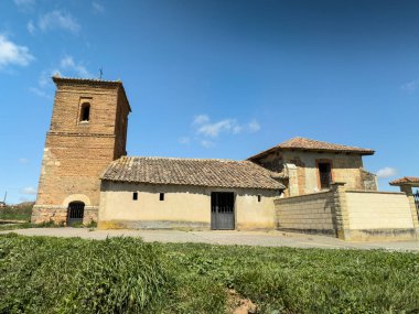 Palencia İspanya 'da çan kulesi ve terk edilmiş nesnelerle dolu eski taştan bir kilisenin kırsal manzarası.