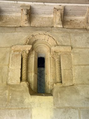 Palencia İspanya 'da tarihi bir kilisede süslemeli sütunlar ve oyulmuş sütunlarla taş Romen penceresi.