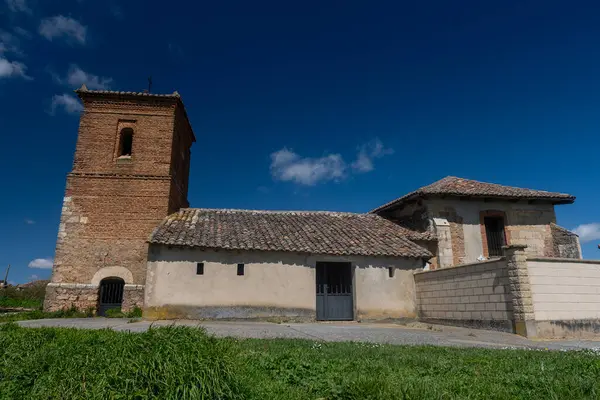Palencia İspanya 'da çan kulesi ve terk edilmiş nesnelerle dolu eski taştan bir kilisenin kırsal manzarası.