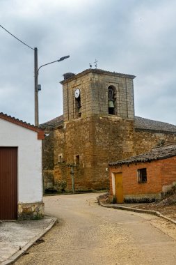 İspanya, Castilla y Leon 'da çan kulesi ve saati olan taşra kilisesi.
