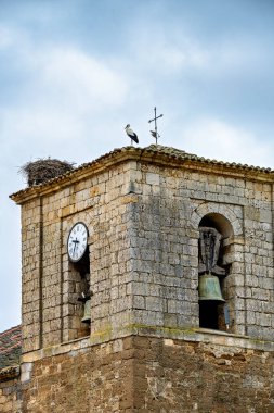 İspanya, Castilla y Leon 'da çan kulesi ve saati olan taşra kilisesi.
