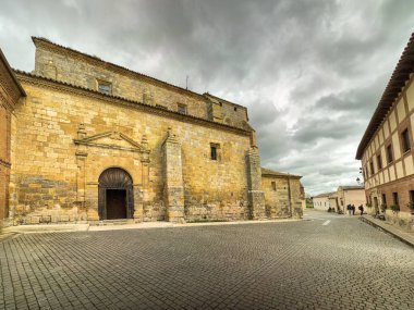 Boadilla del Camino, Palencia 'da çan kulesi ve yıpranmış duvarları olan ağır taş kilise.