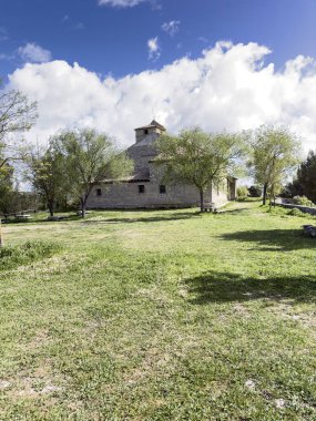 Taştan duvarları, fayanslı çatısı ve gölgeli çimenli çevresi olan Astudillo kırsalında tarihi bir keşiş.