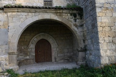 Palacios del Alcor, Palencia 'da yeşil bir yamaçta taş çan kulesi olan tarihi kırsal kilise.