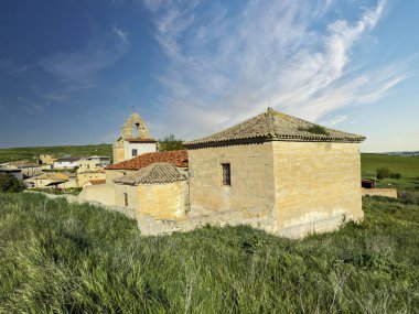 Taştan duvarları, fayanslı çatıları ve Palencia 'nın doğasıyla çevrili çan kulesi olan kırsal kilise.