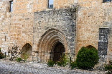Palenzuela 'da çan kulesi ve leylek yuvası olan taş inzivası, çitlerle çevrili.