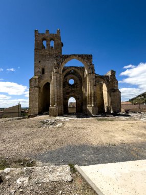 Gotik kilise kalıntıları, yüksek kemerler ve çan kulesi, kısmen çökmüş ama yine de heybetli.