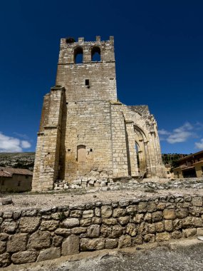 Gotik kilise kalıntıları, yüksek kemerler ve çan kulesi, kısmen çökmüş ama yine de heybetli.