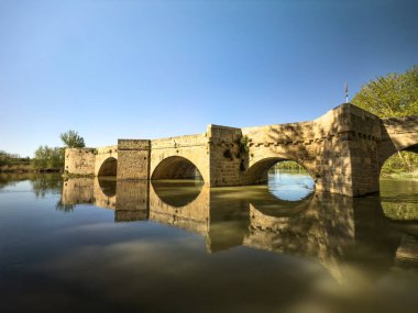 Pisuerga Nehri 'ni geçen etkileyici bir taş köprü olan Puente de Torquemada, Palencia' nın mimari mücevherlerinden biri olarak duruyor.