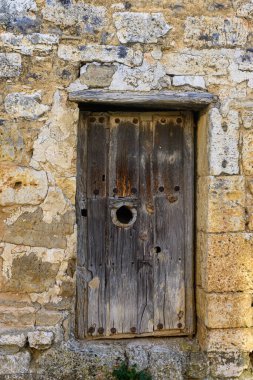 Villamediana köyündeki taştan bir duvarın içindeki eski ahşap kapıya yakın plan.