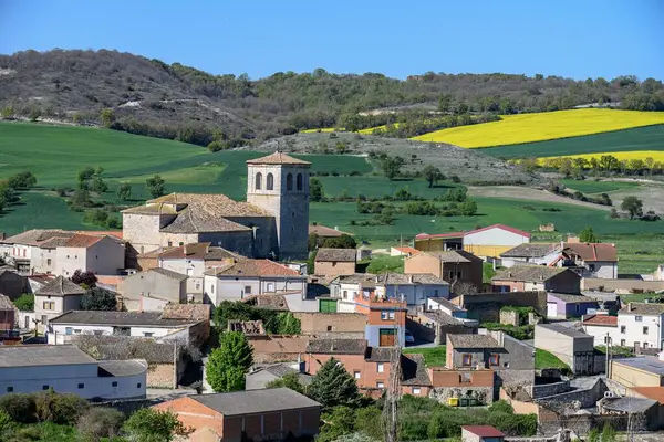 Valdecanas de Cerrato 'nun taştan kilise ve köy merkezi yeşil tarım arazileri ve tepelerle çevrili.