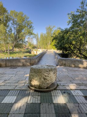 Palencia 'da taş bloklu, kaldırımlı ve doğayı çevreleyen Roma ortaçağ taş köprüsü