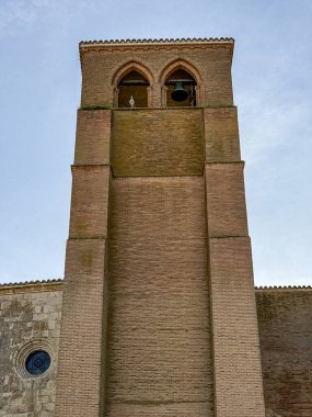 Santa Eugenia 'nın çan kulesinin dikey görüntüsü. Tuğla mimarisi ve açık gökyüzünün altında ikiz kemerler.