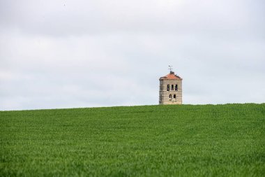 Tarlalarla çevrili Romen kırsal kilisesinin ortaçağ çan kulesi.
