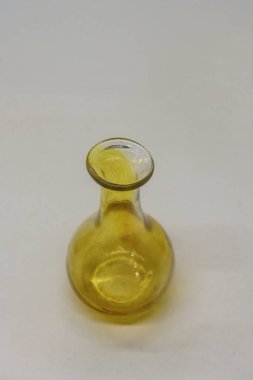 Düz yüzeyi ve geniş açığı olan sarı camdan yapılmış zarif Roma şişesi, Palencia Müzesi.