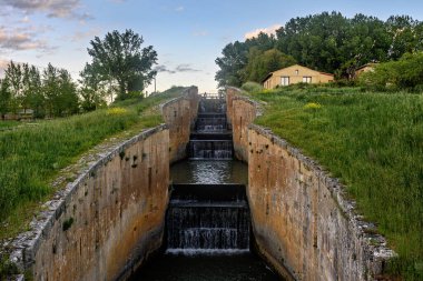 Fromista, Palencia 'daki Castilla Kanalı' nda akan su ile dört basamaklı eski bir taş kilit.