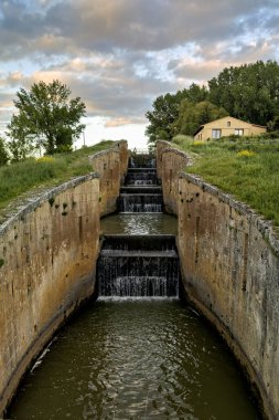 Fromista, Palencia 'daki Castilla Kanalı' nda akan su ile dört basamaklı eski bir taş kilit.